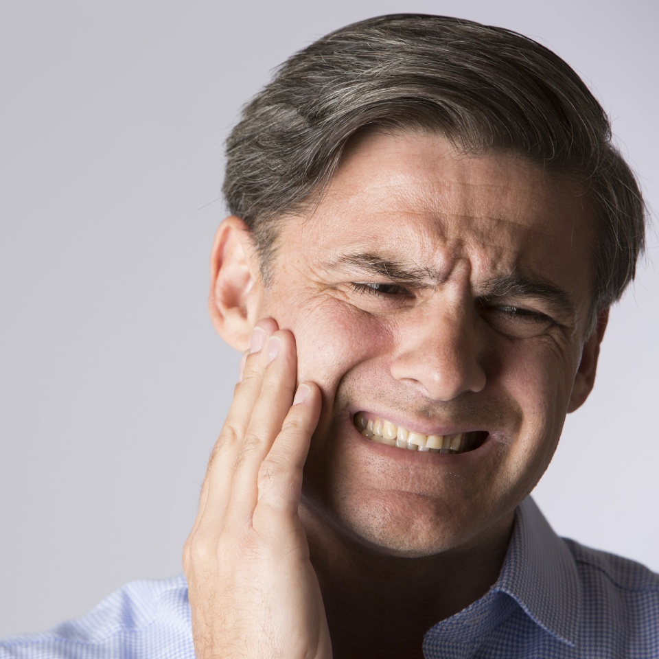 Studio Portrait Of Man Suffering With Toothache