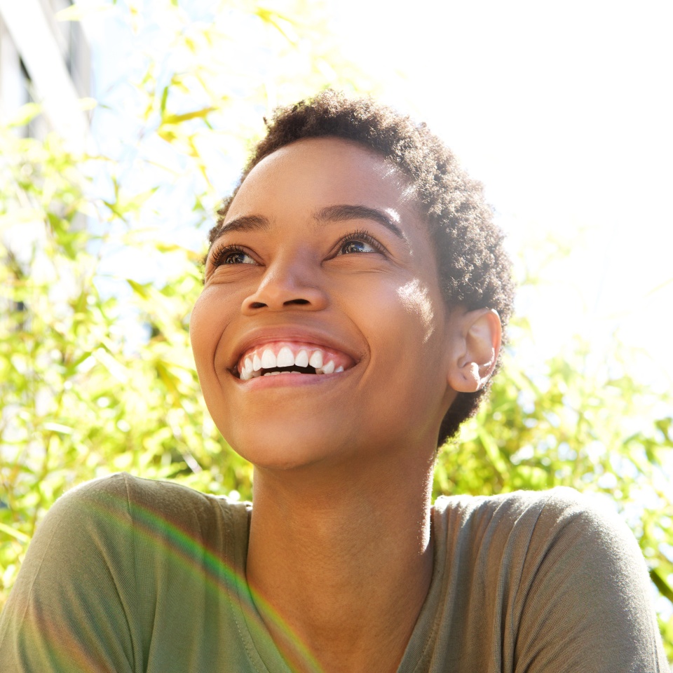 Close up portrait of beautiful young black woman smiling outdoors
